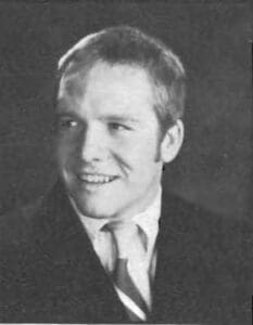 A man in suit and tie smiling for the camera.