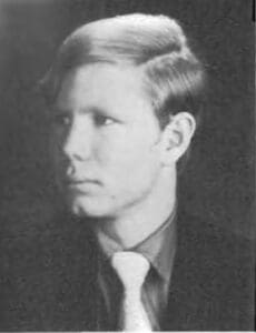 A man in suit and tie with short hair.