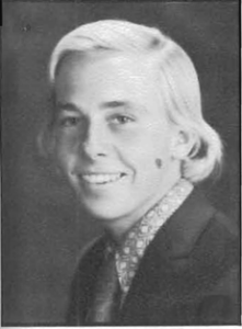 A young man with blonde hair and a suit.